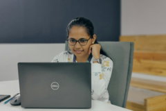 a woman sitting in front of a laptop computer